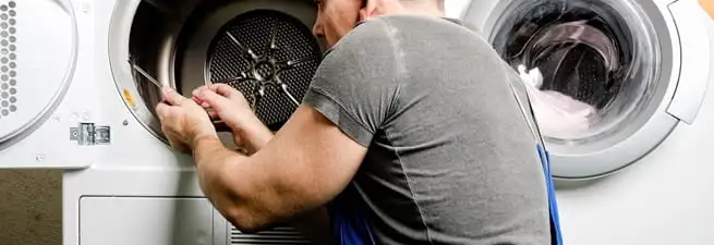 Dryer repair technician fixing a clothes dryer drum in Des Moines, IA