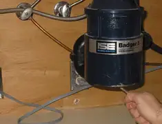 Garbage disposal repair technician tightening the mounting ring under a sink in Des Moines, IA