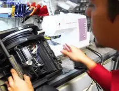 Vacuum repair technician servicing internal components on a workbench in Des Moines, IA