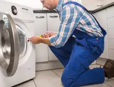 Washing machine repair technician servicing a front-load washer in Des Moines, IA
