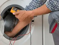 Washing machine repair technician testing a front-load washer with diagnostic tools in Des Moines, IA