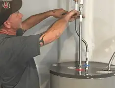 Water heater repair technician tightening supply line connections in Des Moines, IA