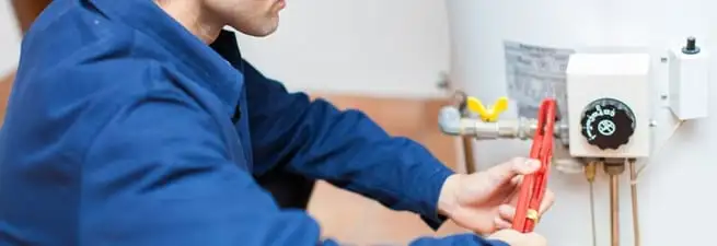 Water heater repair technician adjusting the temperature control and gas valve in Des Moines, IA